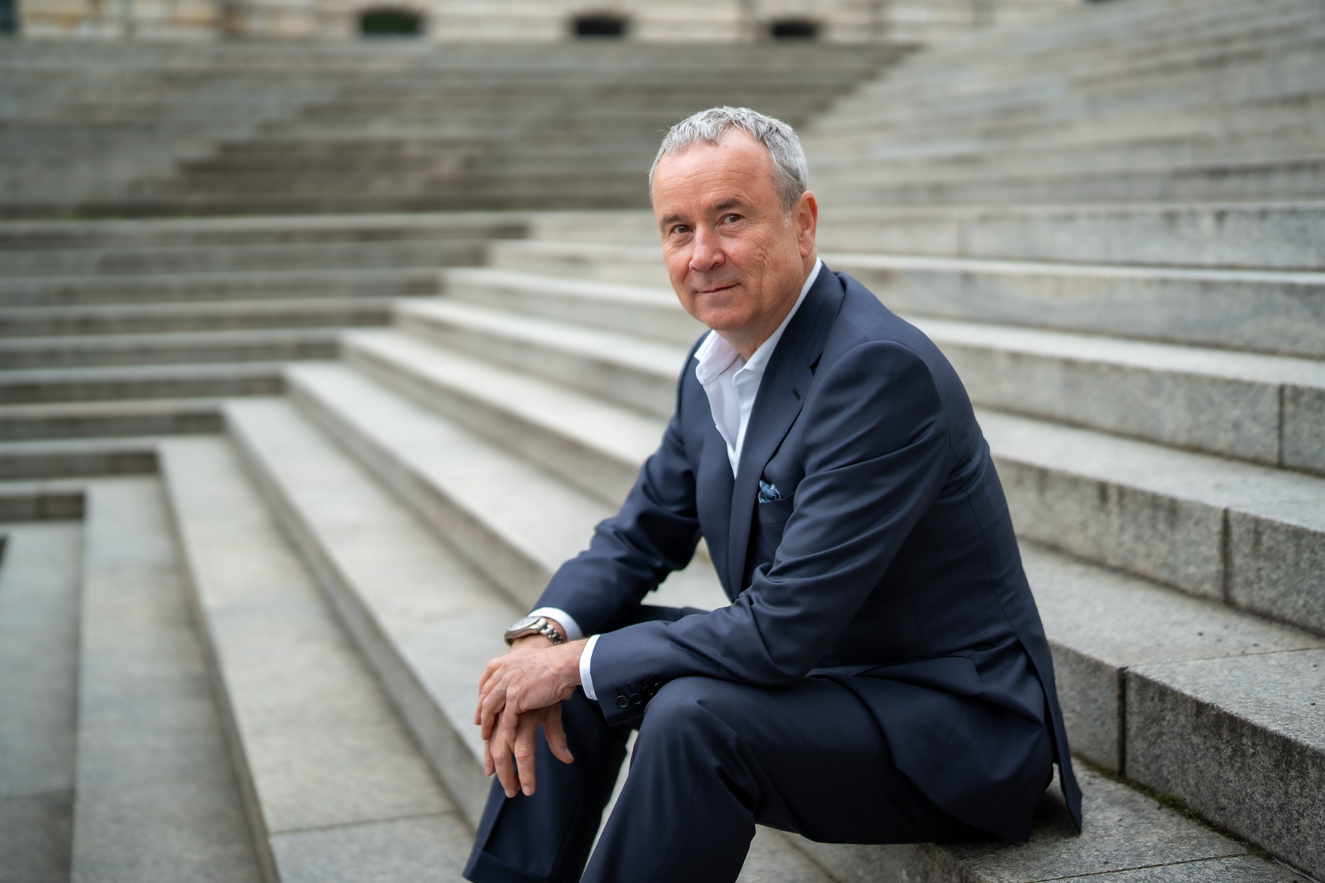 Jörg Franzke, Rechtsanwalt für Restrukturierung, sitzt auf einer Freitreppe